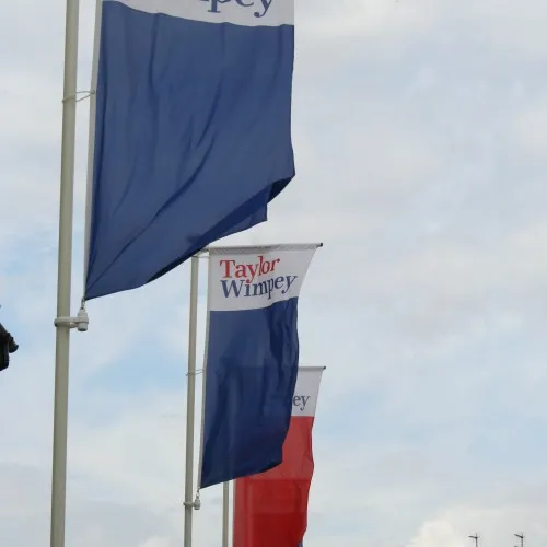 Banner head with rotating arm for fiberglass flagpole
